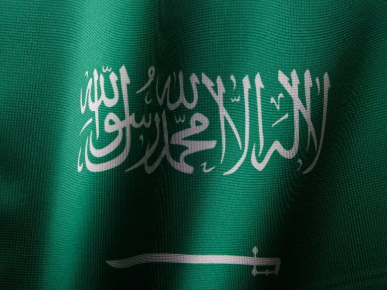 Le Programme Islamique Detailed close-up of the Saudi Arabian flag showcasing the elegant Arabic script and vibrant green color.